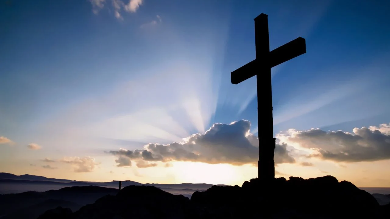 cross on a hill at sunrise