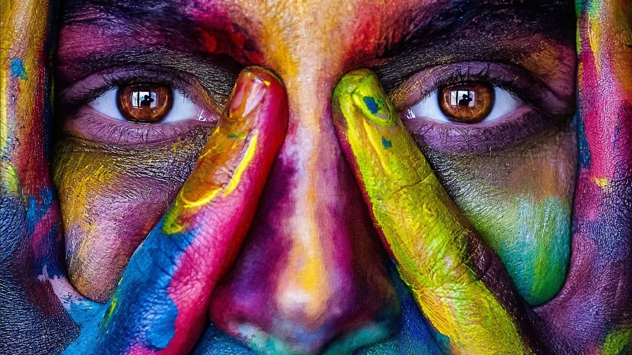 Woman with colorful paint on her face and hands