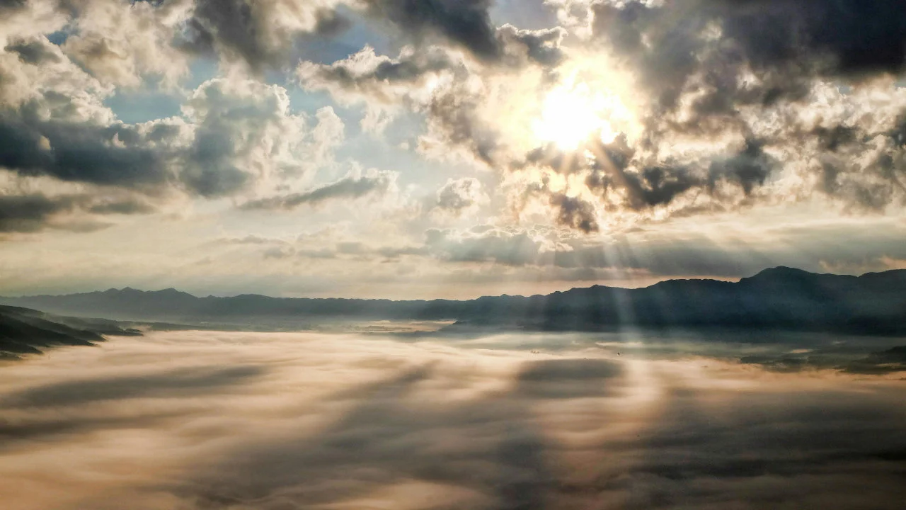 Rays of sunshine breaking through the clouds over the water
