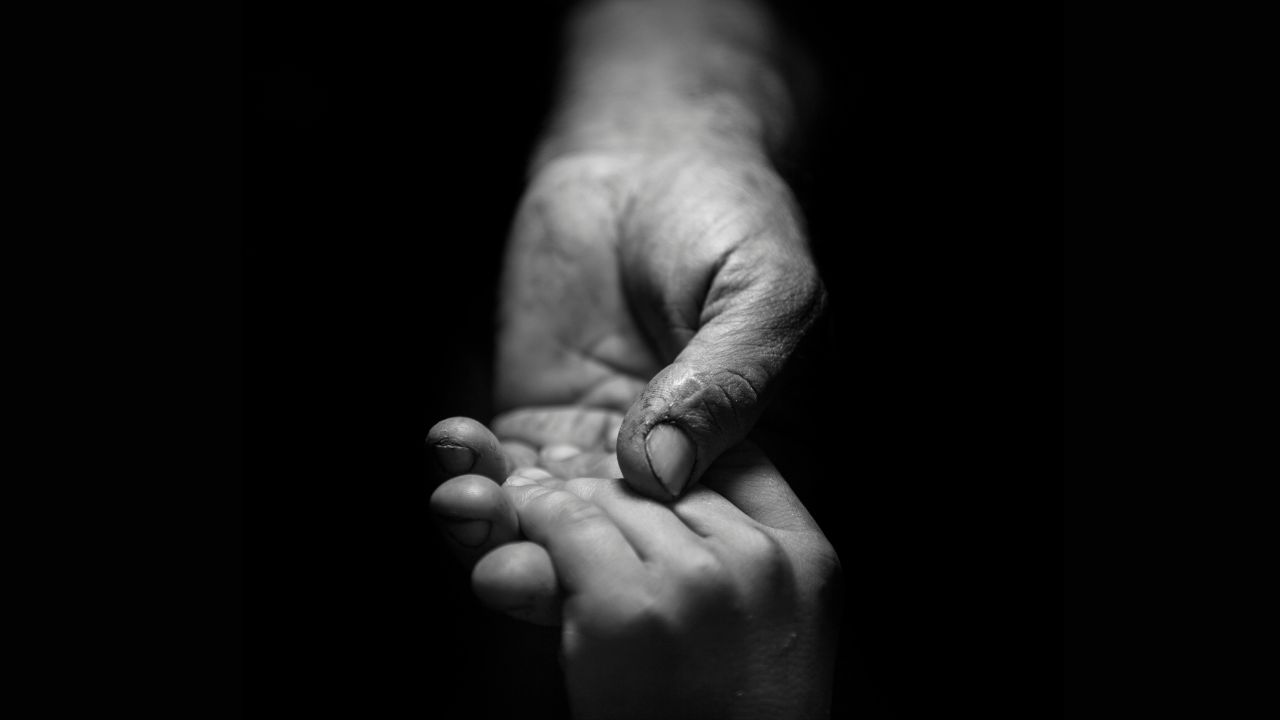 father holding his son's hand