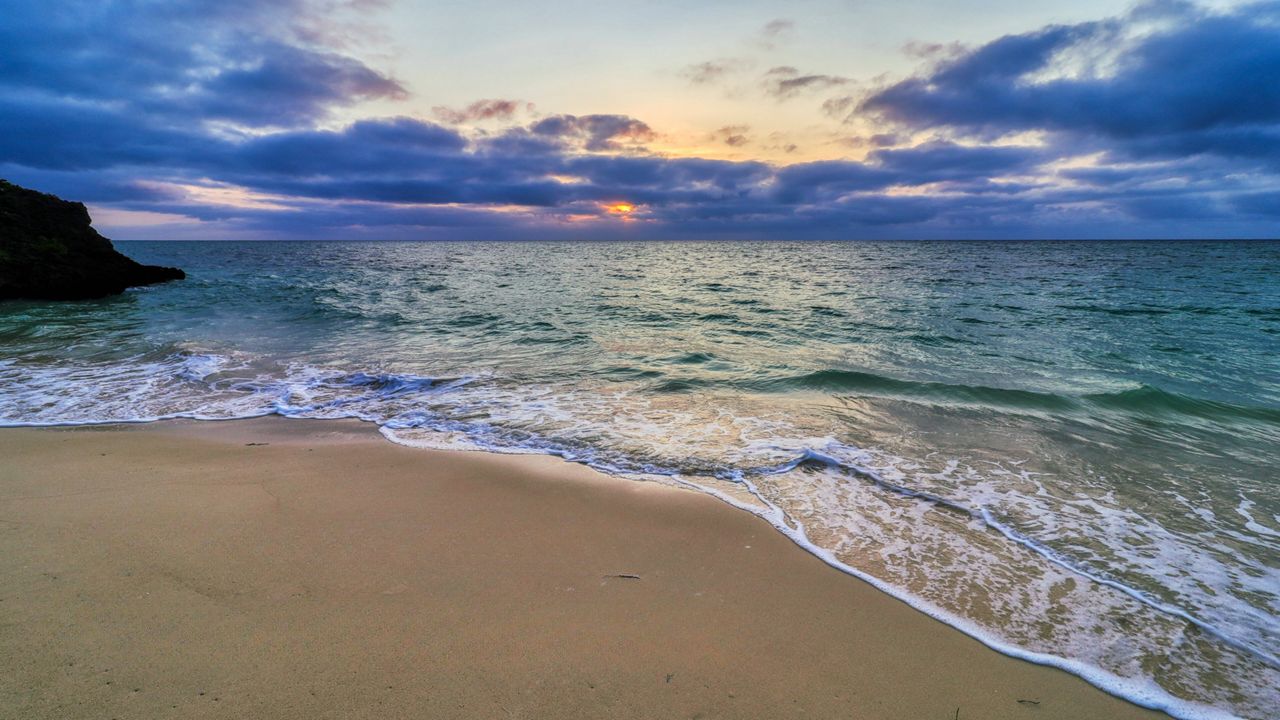 beach with waves on the sand at sunrise